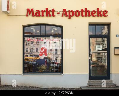 Deutschland, Wismar - 13. Juli 2022: Markt Apotheke, Marktplatz, Pharmabar-Frontfassade mit roten Wörtern. Fenster spiegeln die Fassaden gegenüberliegender Gebäude Stockfoto