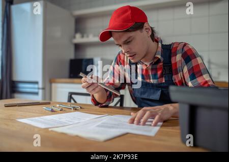 Junger Militärangehöriger konzentrierte sich auf das Lesen der technischen Dokumentation Stockfoto