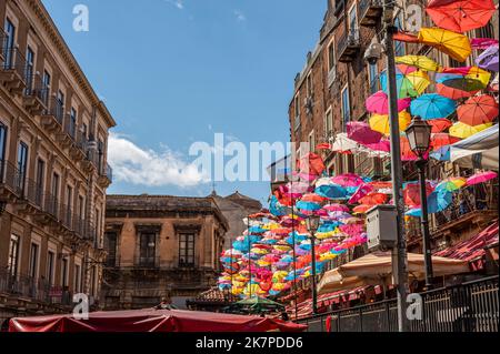 Catania, Italien - 09-23-2022: Wunderschöne Straße im Zentrum von Catania mit vielen bunten Regenschirmen, die über der Straße hängen Stockfoto