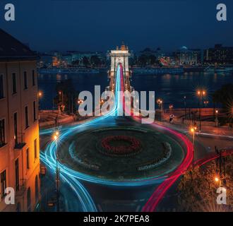 Luftaufnahme des Verkehrs am Clark Adam Square Kreisverkehr mit Szechenyi Kettenbrücke und Donau bei Nacht - Budapest, Ungarn Stockfoto