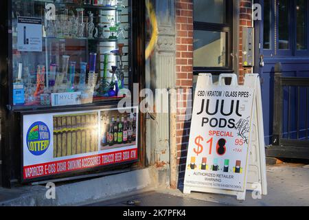 Ein New York City-Smoke-Shop mit Wasserpfeifen im Schaufenster und Werbung für Juul-Schoten, Vapes, Lotterielose und Bier. Stockfoto