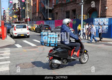 Ein HungryPanda Essenslieferant auf einem Moped in Manhattan Chinatown, New York, September 2022. Hungry Panda 熊貓外賣 asiatische Essenslieferung Stockfoto