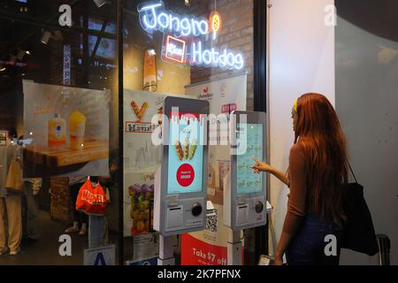 Personen, die einen digitalen Bestellkiosks mit Touchscreen im Jongro-Reis-Hotdog in Manhattans Koreatown, New York, nutzen. Stockfoto