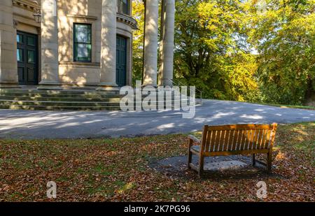 Ein Holzsitz auf dem Gelände der Vereinigten Reformierten Kirche in Saltaire, Yorkshire. Stockfoto