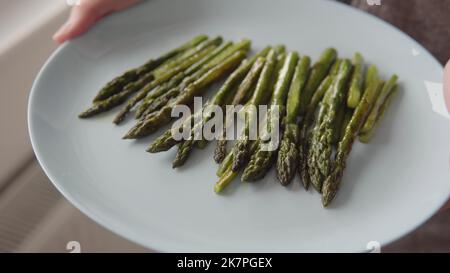 Appetitlich organisch gebraten in Öl grünen Spargel bereit, auf einem Teller close-up-shot essen, gesunde Ernährung Konzept. Stockfoto