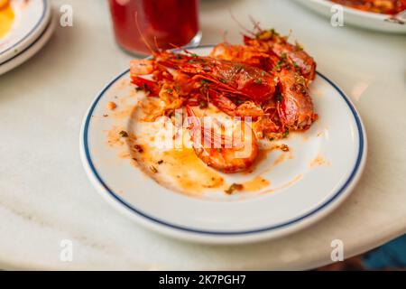 Reste von Garnelen auf einem weißen Teller Stockfoto