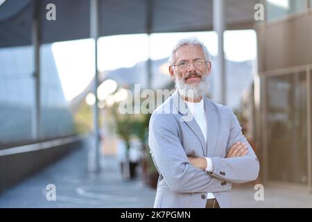 Selbstbewusster, glücklicher, reifer alter Geschäftsmann, der im Freien steht, Porträt. Stockfoto