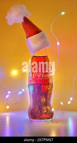 Rom Italien. September - 06. 2020. Coca-Cola-Glaskachelchen in einem Weihnachtshut auf gelbem Hintergrund Stockfoto