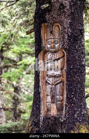 Traditionelle lebende Baumtotem-Schnitzereien auf dem Mount Roberts Trail - Juneau, Alaska, USA Stockfoto