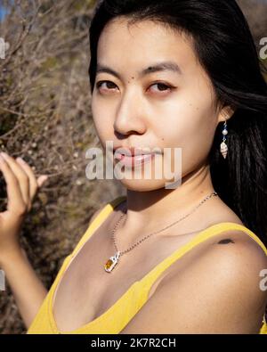 Nahaufnahme Porträt einer jungen Frau, die in einem windgepeitschten Sumpfgebiet steht Stockfoto