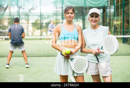Portrait von jungen und älteren Frauen, die Tennis spielen Stockfoto