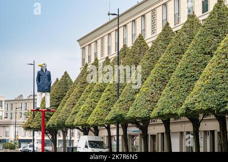 Gepflegte Bäume und eine Vogelmännchen-Statue säumen den Platz im Naturkundemuseum in Le Havre, Frankreich Stockfoto