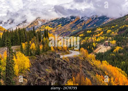 Wolken hängen tief über den San Juan Mountains, die vom Red Mountain Pass auf dem Million Dollar Highway nördlich von Silverton, Colorado, herunterkommen. Stockfoto