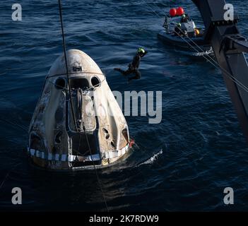 Jacksonville, Florida, USA. 14. Oktober 2022. Support-Teams arbeiten um die Raumsonde SpaceX Crew Dragon Freedom, kurz nachdem sie mit den NASA-Astronauten Kjell Lindgren, Robert Hines, Jessica Watkins und der ESA-Astronautin Samantha Cristoforetti an Bord im Atlantik vor der Küste von Jacksonville, Florida, gelandet ist, am Freitag, den 14. Oktober 2022. Lindgren, Hines, Watkins und Cristoforetti kehren nach 170 Tagen im Weltall als Teil der Expeditionen 67 und 68 an Bord der Internationalen Raumstation zurück Quelle: Bill Ingalls/NASA/ZUMA Press Wire Service/ZUMAPRESS.com/Alamy Live News Stockfoto