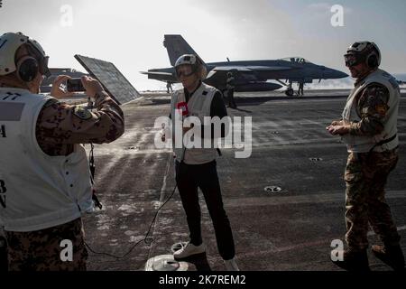 221017-N-MW880-1148 ADRIATISCHES MEER (17. Oktober 2022) Oberstleutnant Florian Raebel, links, und Royal Navy Cmdr. Grant Kelly, rechts, beide dem Alliierten Joint Force Command Naples zugewiesen, nimmt ein Video von Alexandra Dinu, Reporterin von Digi24, an Bord des Flugzeugträgers USS George H. W. Bush (CVN 77) der Nimitz-Klasse während der von der NATO geführten Wachsamkeit Neptune Strike 22,2 (NEST 22,2) in der Adria am 17. Oktober 2022 auf. NEST 22,2 ist die natürliche Weiterentwicklung der Fähigkeit der NATO, die High-End-Fähigkeiten der maritimen Kriegsführung einer Trägerstreikgruppe zu integrieren, um die Verteidigung des Bündnisses in Europa zu unterstützen. Stockfoto