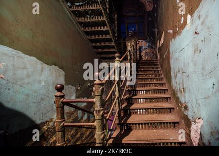 Alte, geschmiedete eiserne Treppe in einem schäbigen historischen Gebäude Stockfoto