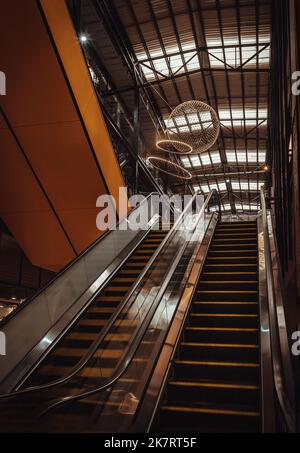 Bangkok, Thailand - Oct 10, 2022 : Architekturdesign modernes Interieur des Gebäudes dekorativ mit kreisförmiger Pendelleuchte über Rolltreppen. Selecti Stockfoto
