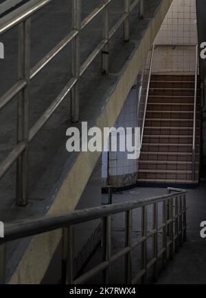 Bangkok, Thailand - Sep 30, 2022 : Treppen führen zur Innenansicht der öffentlichen Unterführung mit weiß gefliesten Wänden und CCTV. Raum für Text, selektiver Fokus Stockfoto