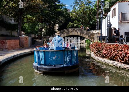 Die Legende des Flussschiffs in einem blauen Boot voller Touristen führt entlang des Flusses San Antonio entlang des River Walk in der Innenstadt von San Antonio, Texas. Auf S Stockfoto