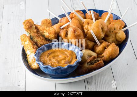 Eine Platte mit frittierten Vorspeisen, serviert mit heißem Senf zum Eintauchen. Stockfoto