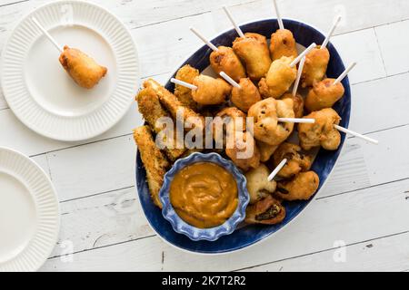 Draufsicht auf eine Platte mit frittierten Vorspeisen, die zum Teilen bereit sind. Stockfoto