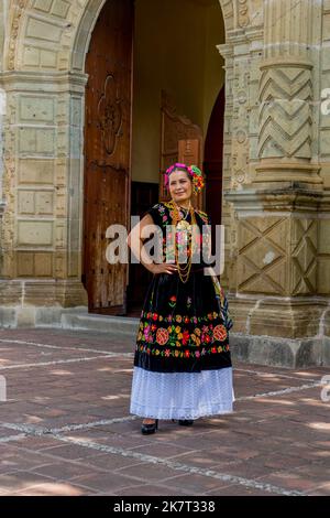 Eine einheimische Frau in traditioneller Kleidung posiert für Fotos in einer Straße im Barrio de Jalatlaco, in Oaxaca-Stadt, Mexiko. Stockfoto