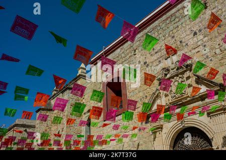 Eine Straßenszene mit Papel picados, einem traditionellen mexikanischen Dekorationshandwerk, das im Stadtzentrum von OA durch das Schneiden aufwändiger Designs in Papierbögen hergestellt wurde Stockfoto