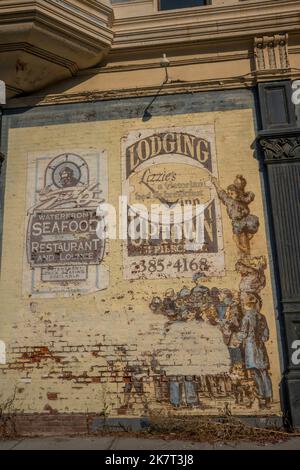 Eine alte bemalte Anzeige auf der Seite des historischen Hastings Building, erbaut 1889, in Port Townsend, Jefferson County, Washington State, Stockfoto