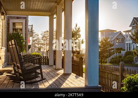 Schaukelstühle auf einer Veranda blicken auf das Licht des Abendlichts am Pazifik in Seabrook, Washington State, USA. Stockfoto