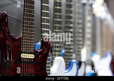 E-Gitarren an einer Wand im Musikgeschäft. Selektiver Fokus. Stockfoto