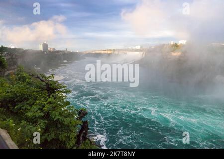 Niagara Horseshoe fällt bei Sonnenuntergang - blaues Wasser, Dunst und wolkiger Himmel. Dramatische Töne Stockfoto