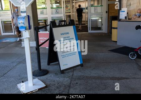 North Vancouver, Kanada - 18. Juli 2022: Blick auf das Schild am Eingang des Lions Gate Hospital Bitte halten Sie den Impfnachweis bereit Stockfoto