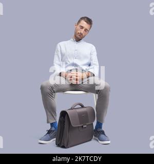 Fauler, müde Geschäftsmann sitzt auf einem Stuhl und schläft ein Stockfoto