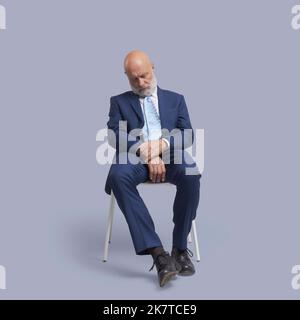 Senior Business Businessman sitzt auf einem Stuhl und schläft Stockfoto
