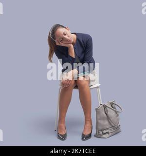 Junge elegante Geschäftsfrau sitzt auf einem Stuhl und schläft Stockfoto
