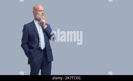 Unternehmensleitung mit Hand auf Kinn stehen und denken, Geschäftsstrategie und Planungskonzept Stockfoto