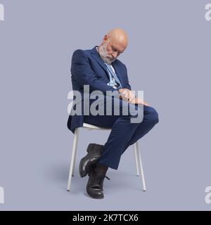Senior Business Businessman sitzt auf einem Stuhl und schläft Stockfoto
