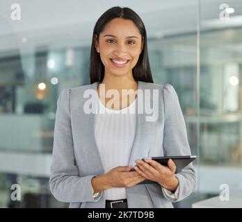 Meine Ziele halten mich in Gang. Eine junge Geschäftsfrau, die in einem modernen Büro ein digitales Tablet nutzt. Stockfoto