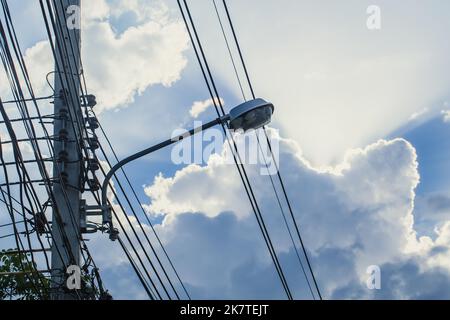 Strom-Stromkabel mit Straßenlaterne in der Stadt Morgen Tag schönen Himmel Hintergrund Stockfoto