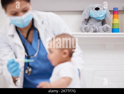 Waren fast fertig. Ein Arzt, der einem Baby in einem Krankenhaus Medikamente gibt. Stockfoto