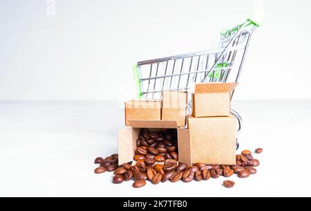 Mini-Einkaufswagen und kleine Kartons voller gerösteter Kaffeebohnen, isoliert auf einem neutralen Hintergrund. E-Commerce und Kaffee Lieferung Serv Stockfoto