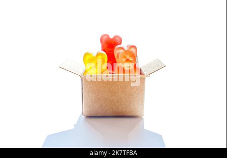 Miniatur-Lieferbox voll von bunten Bären geformt kauen Süßigkeiten isoliert auf weißem Hintergrund. Konzept für Partyzubehör. Stockfoto