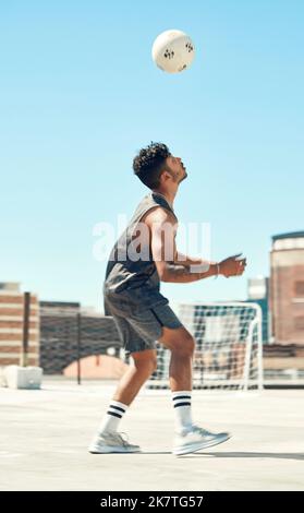 Training, Fußball und Mann mit Ball in Air-Trick auf dem Dach der Stadt in Brasilien für das Spielen im Freien. Fußball, Training und Athlet männliche Übungstechnik Stockfoto