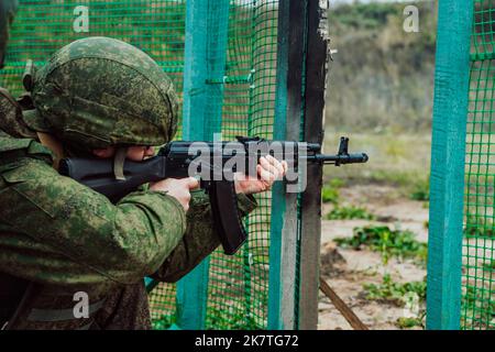 Tatarstan, Russland. 10. Oktober 2022. Mobilisierte russische Soldaten werden auf dem Trainingsgelände einer Kampfausbildung unterzogen. Soldat zielt auf Waffe Stockfoto