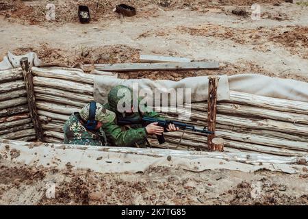 Tatarstan, Russland. 10. Oktober 2022. Mobilisierte russische Soldaten werden auf dem Trainingsgelände einer Kampfausbildung unterzogen. Zwei Soldaten in einem Graben Stockfoto