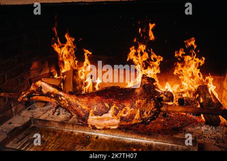 Das Lamm wird komplett auf einem Spieß auf dem Feuer gekocht. Kochen Stockfoto