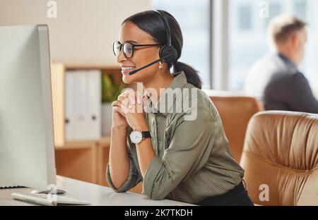 Kunden lieben ihre freundliche Art am Telefon. Eine junge Geschäftsfrau, die an einem Computer in einem Callcenter arbeitet. Stockfoto