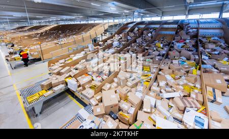 Köln, Deutschland. 19. Oktober 2022. Paketzusteller sortieren und legen Pakete in ihre Zustellfahrzeuge an einer DHL-Zustellbasis der Deutschen Post. Deutsche Post DHL erwartet in der diesjährigen Weihnachtsshopping-Saison erneut Massen von Paketen. Quelle: Rolf Vennenbernd/dpa/Alamy Live News Stockfoto
