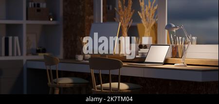 Komfortabler Heimarbeitsplatz bei Nacht Innenarchitektur mit Laptop weißen Bildschirm Mockup, Tischlampe, PC-Computer und Zubehör auf dem Tisch gegen den Wind Stockfoto