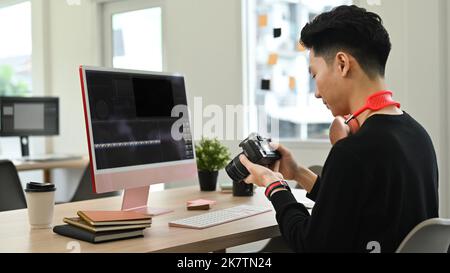 Rückansicht des jungen männlichen Videoeditors, der Audio-Film-Montage mit professionellem Computer im kreativen Bürostudio bearbeitet Stockfoto